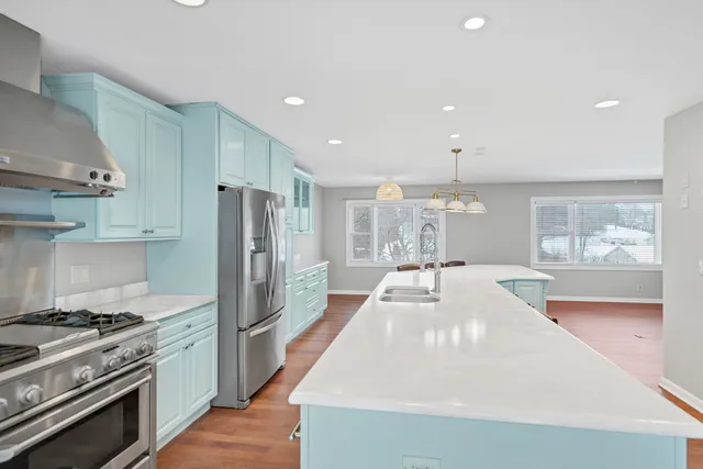 a kitchen with kitchen island a stove a table and chairs in it
