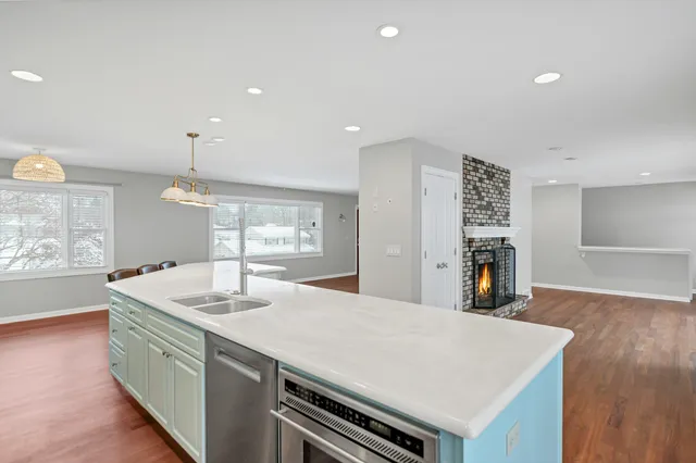 a living room with furniture a fireplace and wooden floor