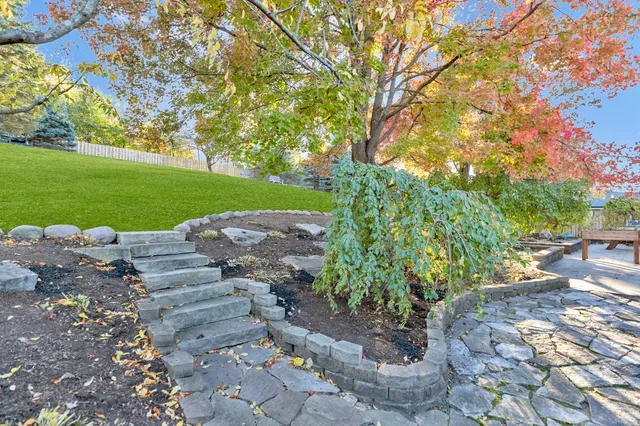 a front view of a house with a garden and trees