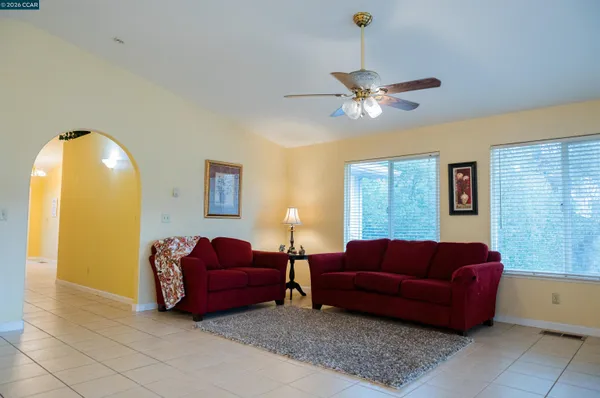 a living room with furniture a ceiling fan and a window