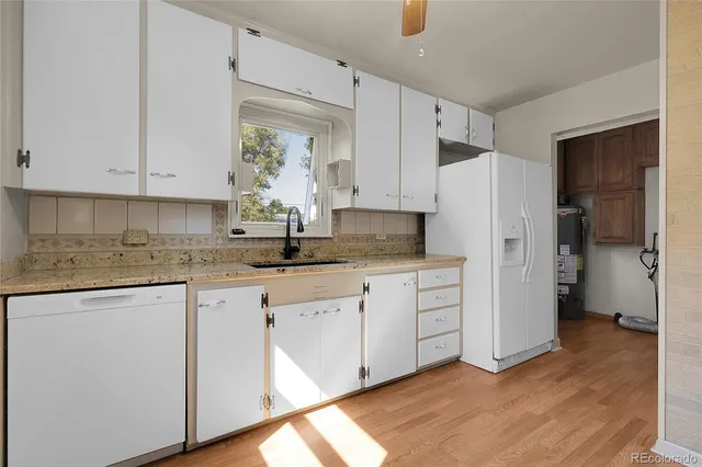 a kitchen with white cabinets and refrigerator