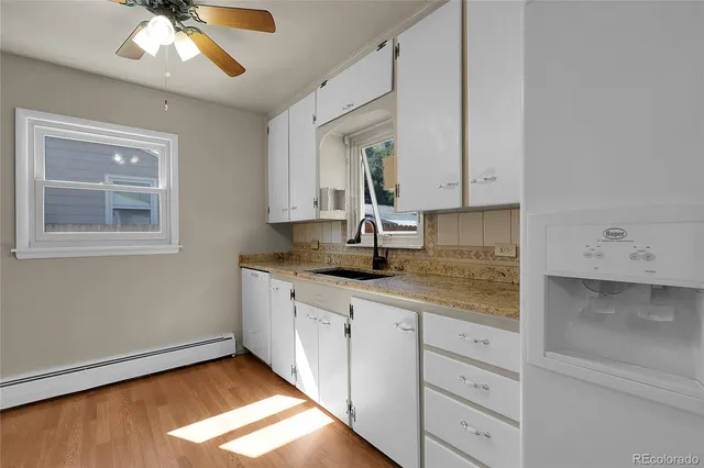 a kitchen with granite countertop white cabinets and white appliances