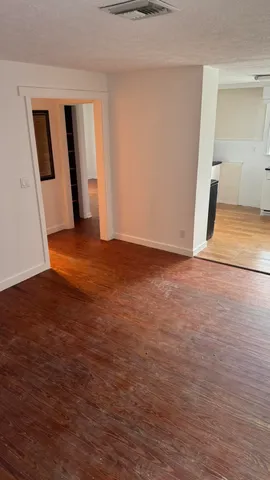 a view of an empty room with wooden floor