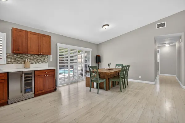 a dining room with furniture wooden floor a rug and a painting