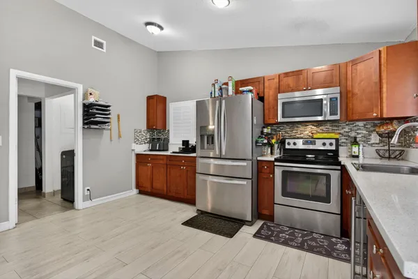 a kitchen with granite countertop a refrigerator and a stove top oven