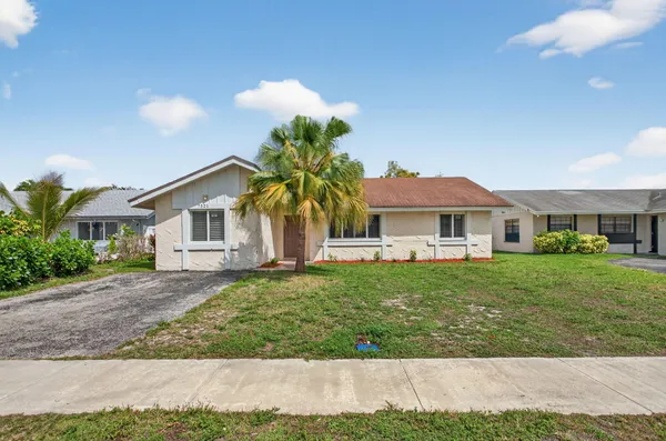 a front view of a house with a garden and yard