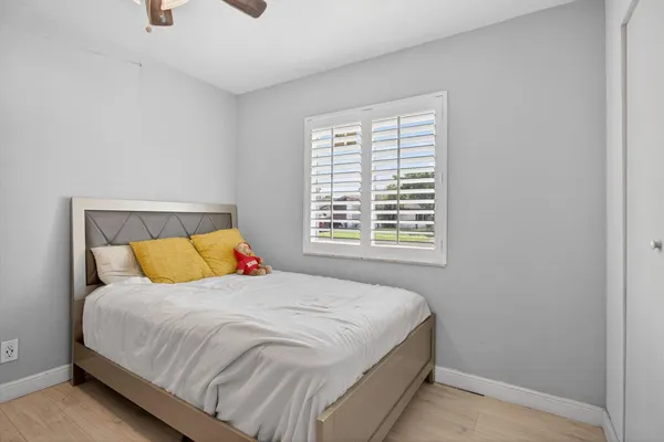 a bedroom with a bed a window and flowerpot