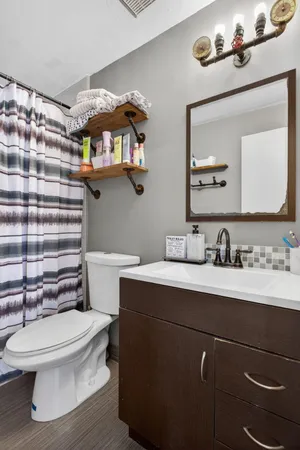 a bathroom with a sink a toilet and a mirror