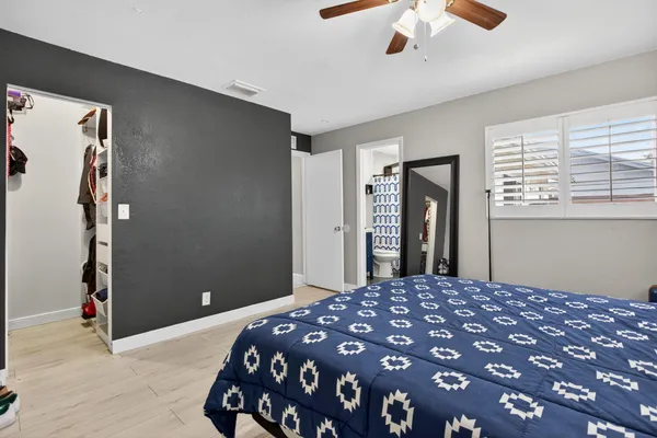 a bedroom with a large bed and a chandelier