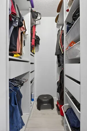 a view of walk in closet with clothes and shoes