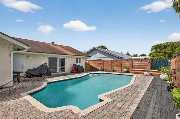 a view of a house with backyard sitting area and swimming pool