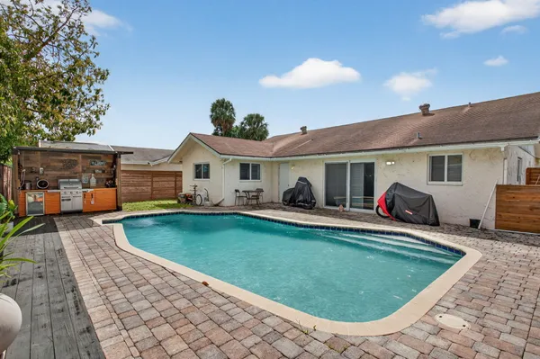a view of a house with swimming pool and sitting area