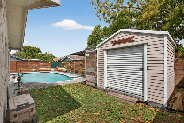 a view of a backyard with plants and white umbrellas
