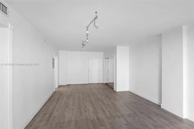 a view of a room with wooden floor and white walls