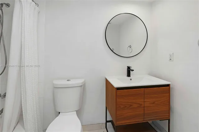 a bathroom with a toilet a sink and a mirror