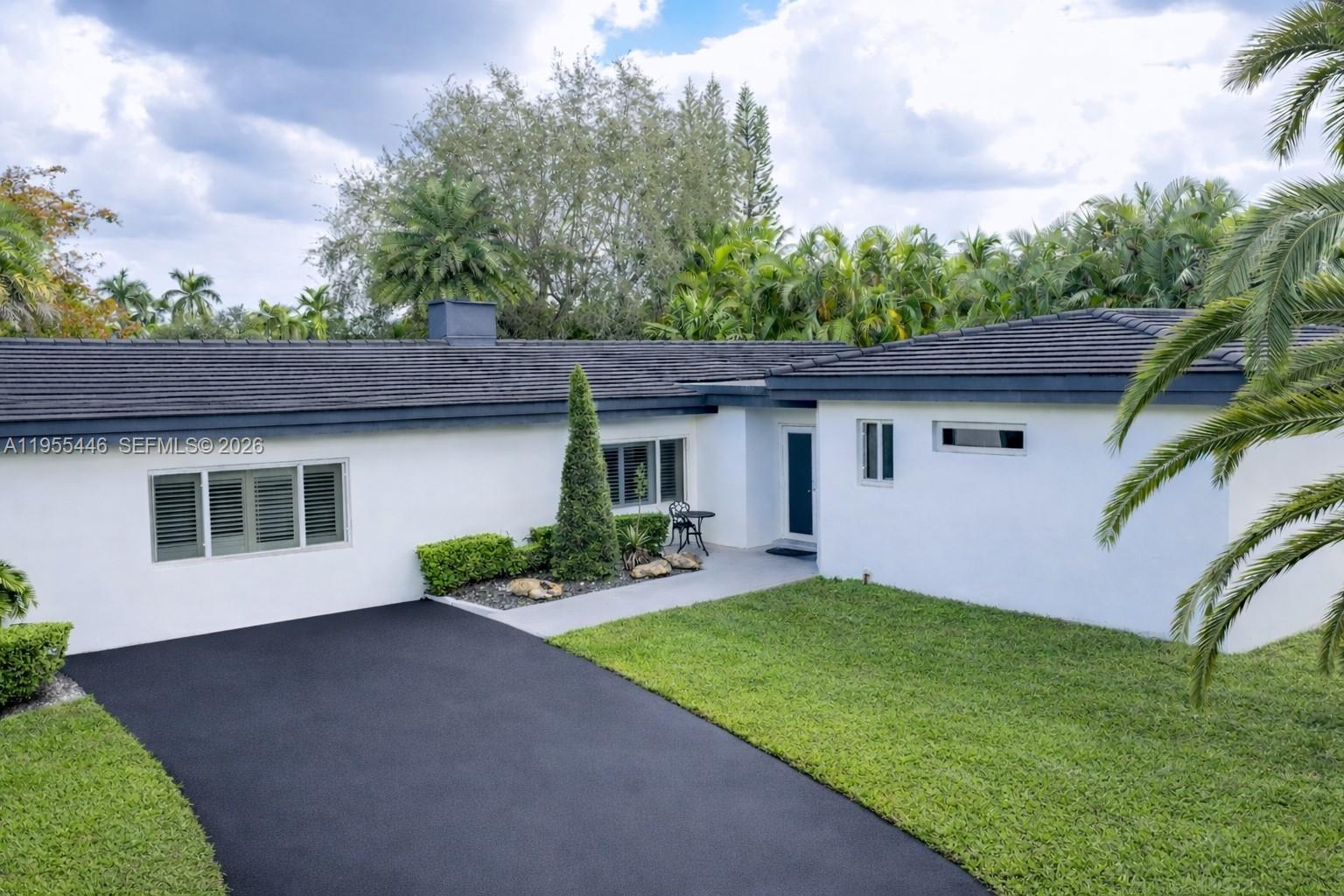 241 Southwest 129th Avenue Miami, FL 33184 - Photo 2 of 28 a front view of a house with a yard and garage