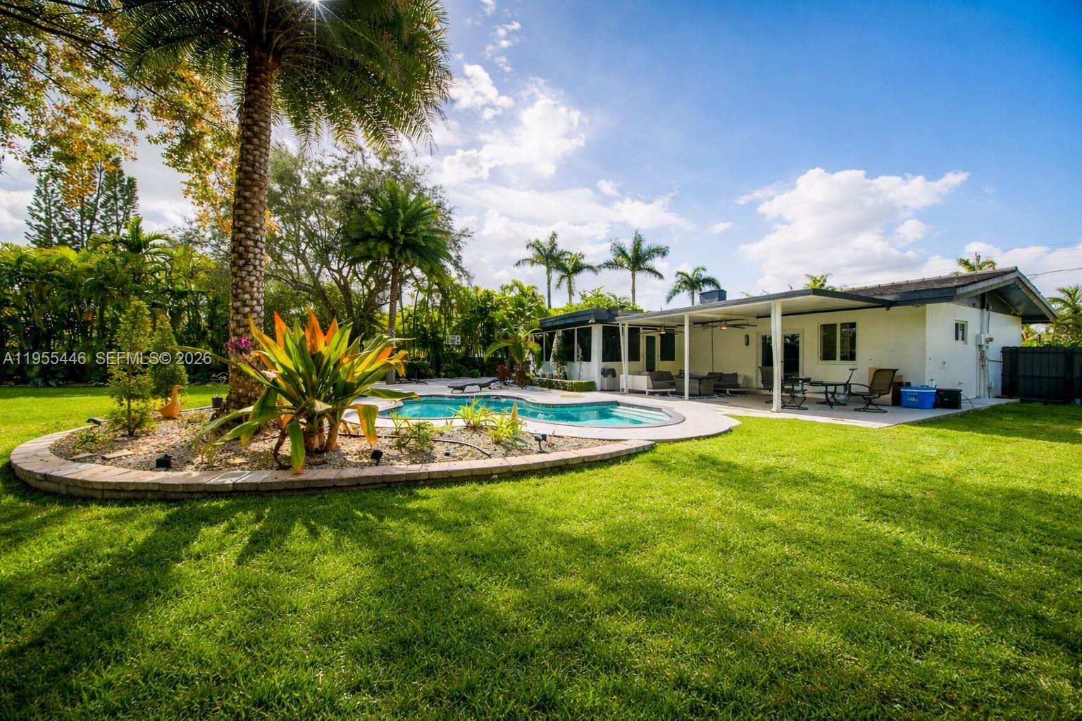 241 Southwest 129th Avenue Miami, FL 33184 - Photo 23 of 28 a view of a house with a big yard and palm trees