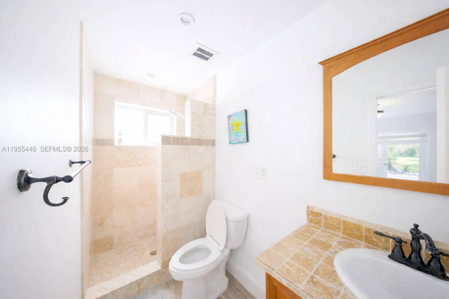241 Southwest 129th Avenue Miami, FL 33184 - Photo 27 of 28 a bathroom with a granite countertop toilet sink and mirror