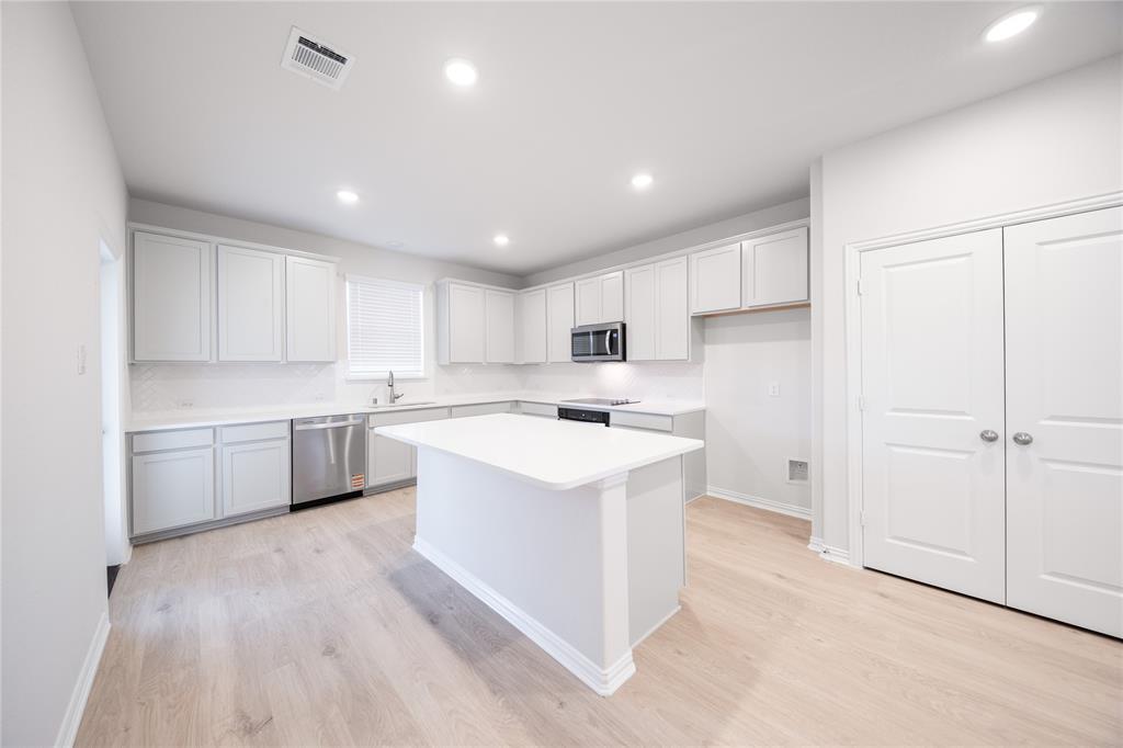 2606 Hawkins Street Anna, TX 75409 - Photo 11 of 31 a kitchen with a sink a counter top space and cabinets