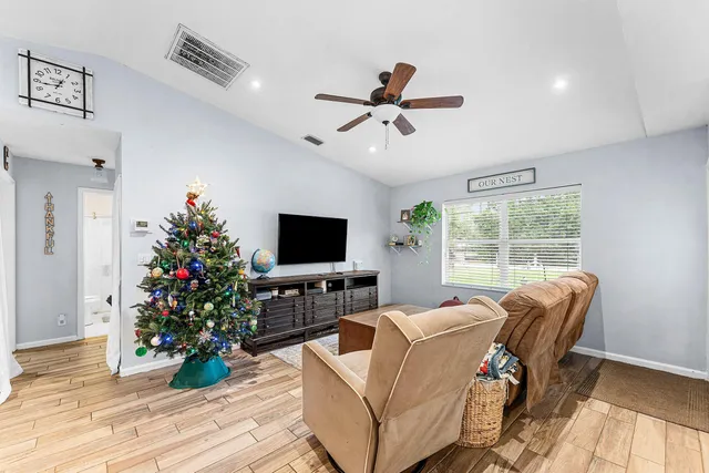 a living room with furniture a flat screen tv and a potted plant