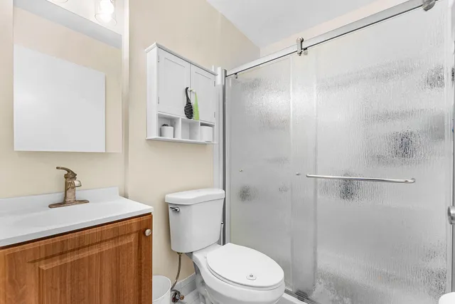 a bathroom with a shower sink vanity and toilet
