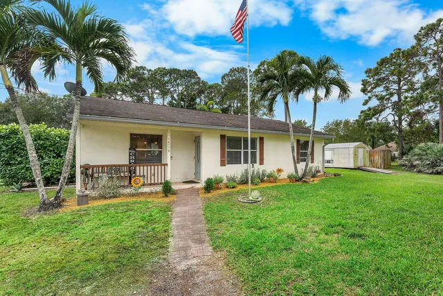 a front view of house with a garden and patio