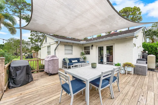 a view of a patio with table and chairs with wooden floor and fence