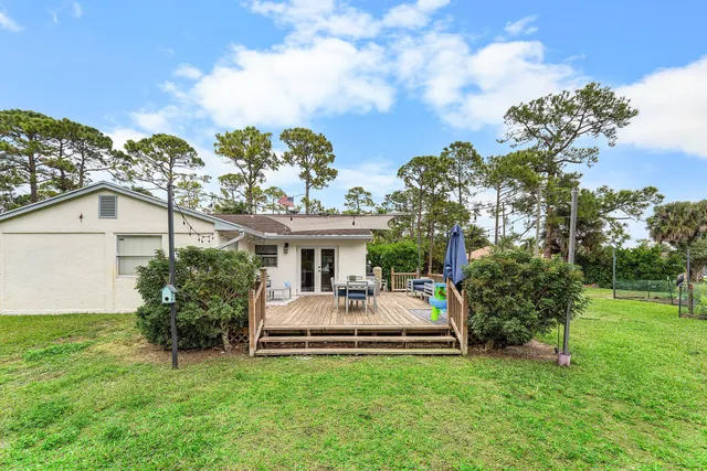 a white house that has a big yard and a fountain