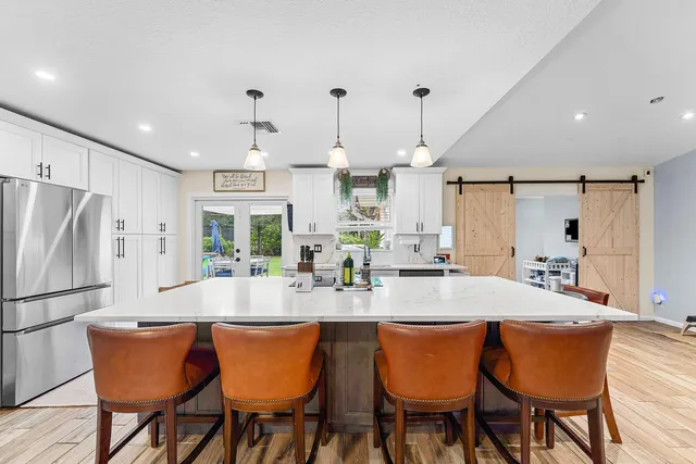 a kitchen with granite countertop a dining table chairs and white cabinets