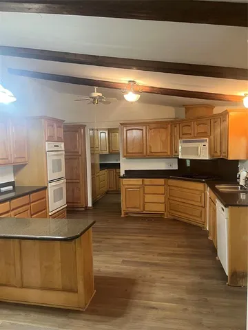a large kitchen with cabinets and wooden floor