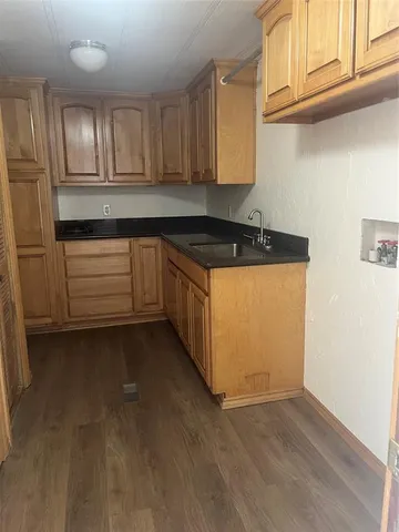 a kitchen with granite countertop wooden cabinets and a stove