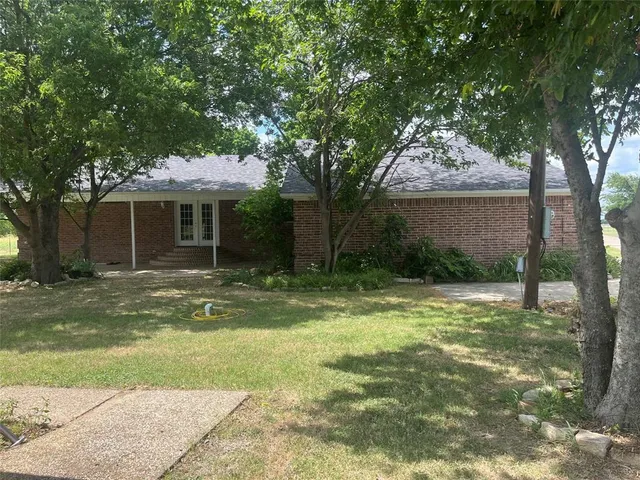 a view of a house with backyard and a tree