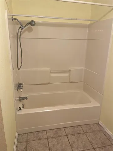 a bathroom with a bath tub with a shower