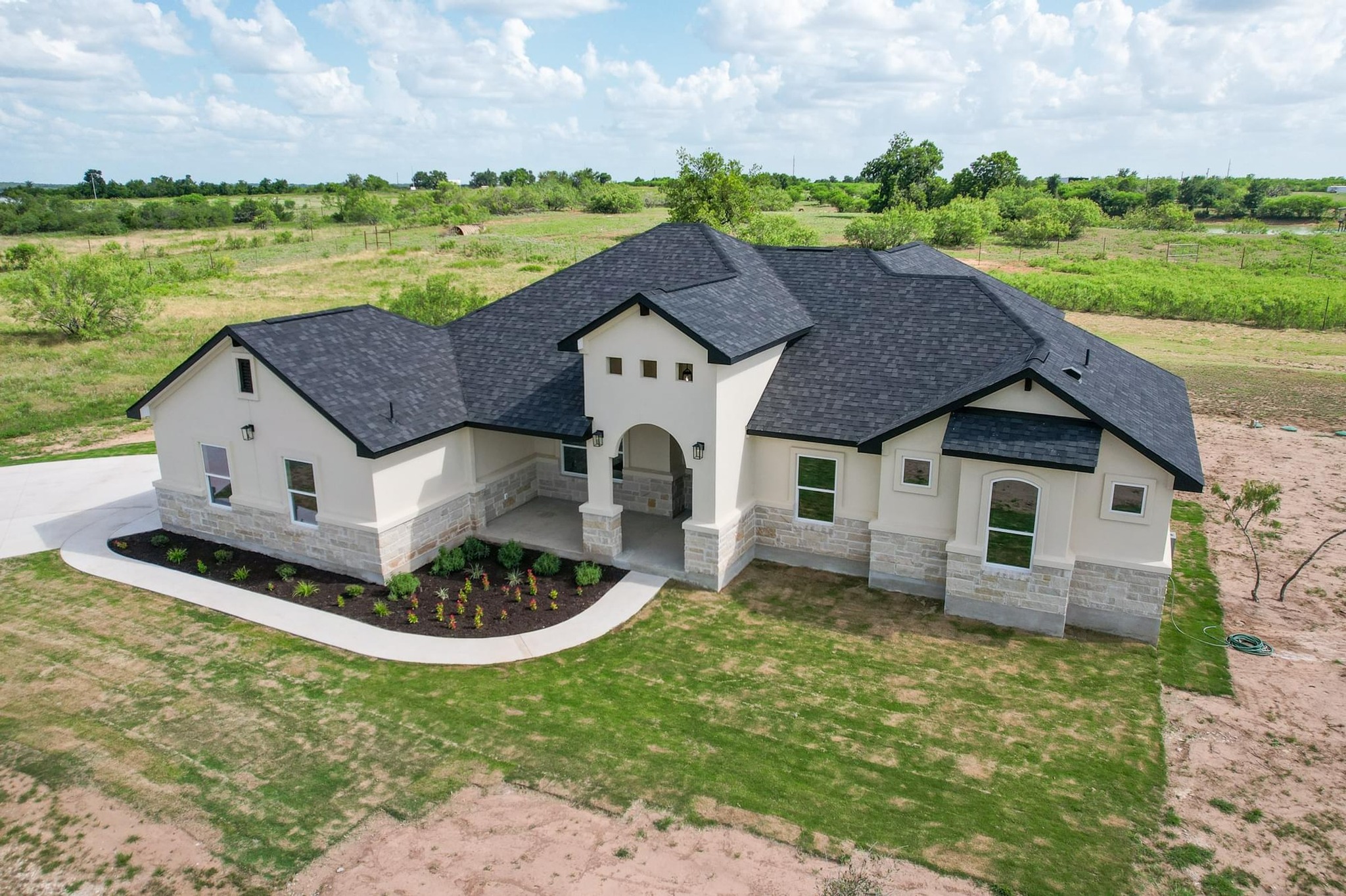 1136 County Road 484 Elgin, TX 78621 - Photo 36 of 37 French country home featuring stone siding, stucco siding, a front yard, and a view of countryside