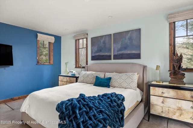 a bedroom with a large bed and a flat tv screen on dresser