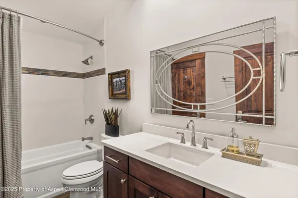 a bathroom with a granite countertop sink mirror toilet and bathtub