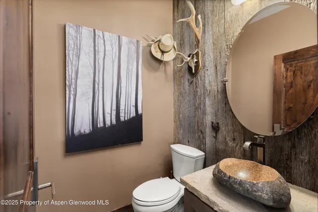 a bathroom with a toilet a sink and mirror