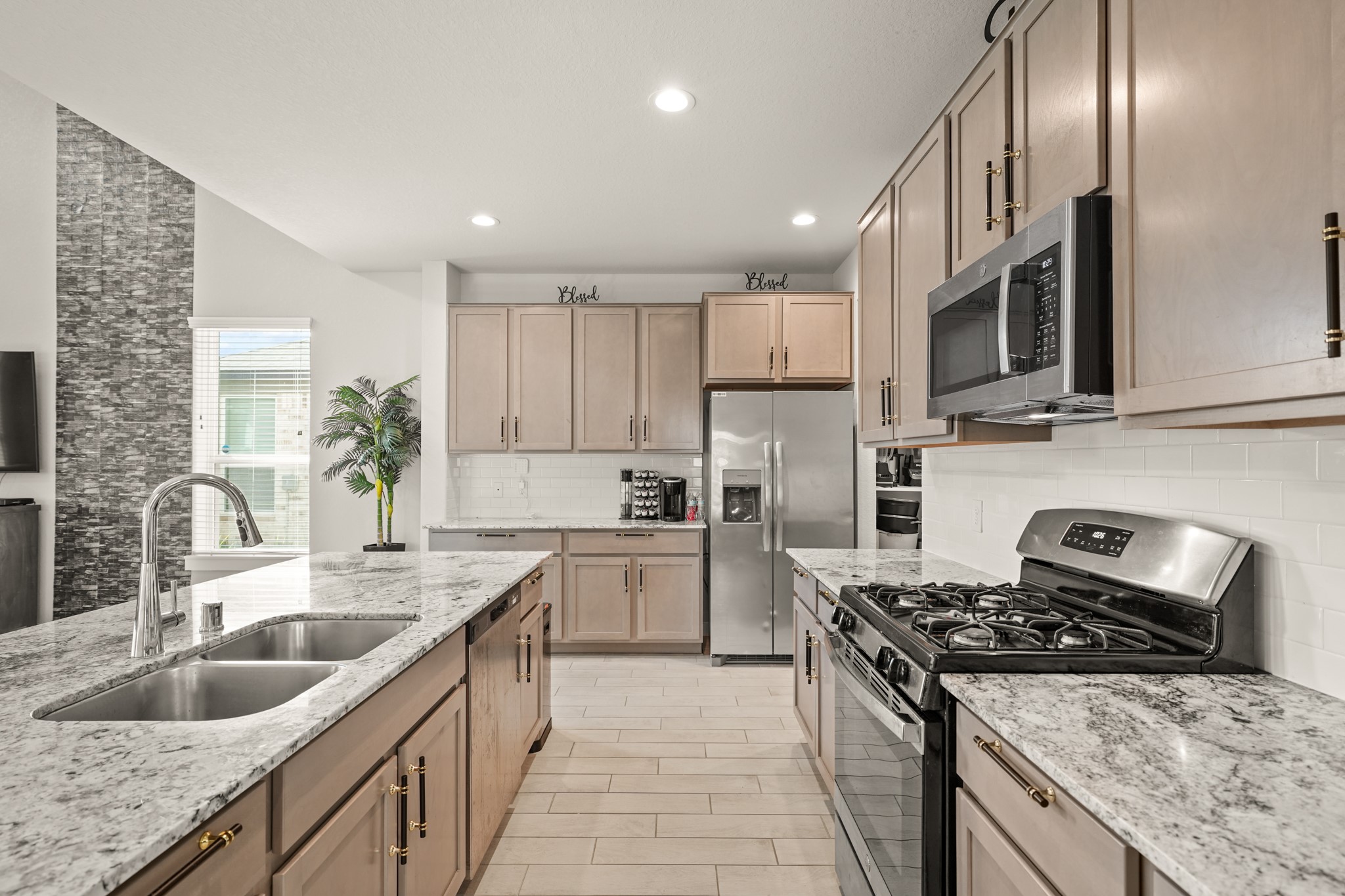 18419 Windy Knl Way Houston, TX 77084 - Photo 13 of 50 a kitchen with stainless steel appliances granite countertop a sink stove microwave and refrigerator