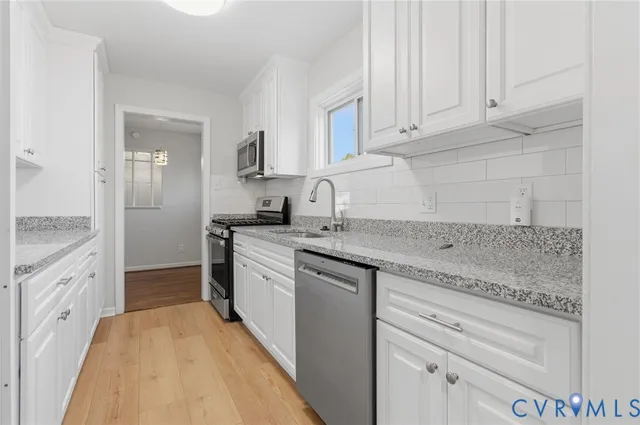 a kitchen with granite countertop white cabinets and white appliances