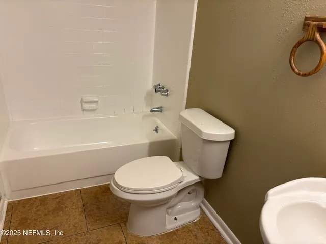 a white toilet sitting next to a bath tub
