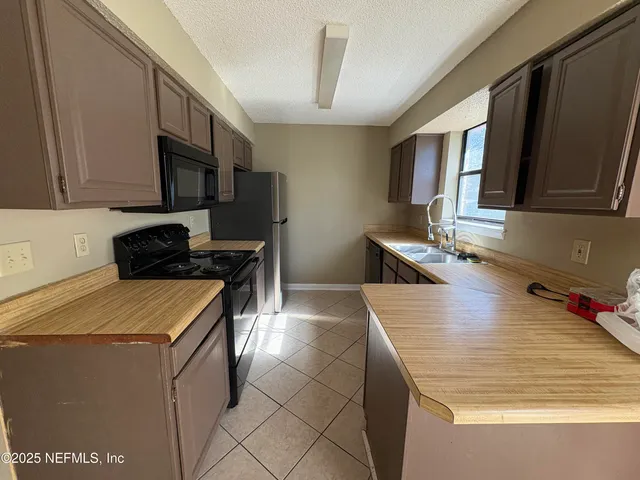 a kitchen that has a sink and a stove in it
