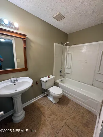 a bathroom with a toilet a sink and bathtub