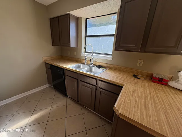 a kitchen with a sink cabinets and window