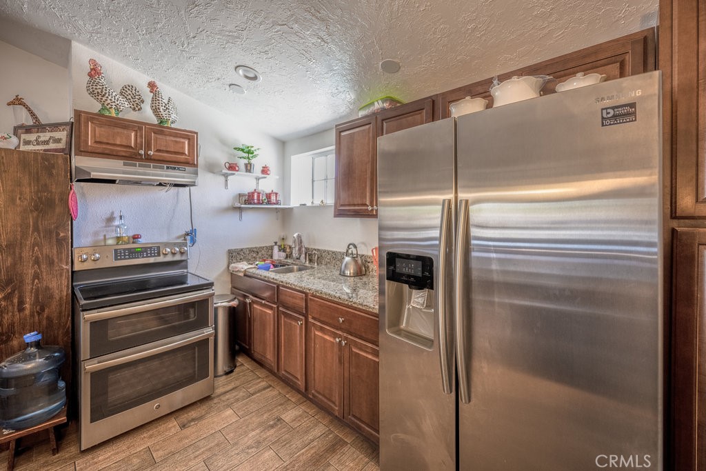 9555 1/2 Hierba Road Agua Dulce, CA 91390 - Photo 8 of 26 a kitchen with cabinets and stainless steel appliances