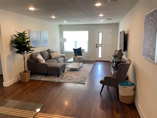 a living room with furniture and a wooden floor
