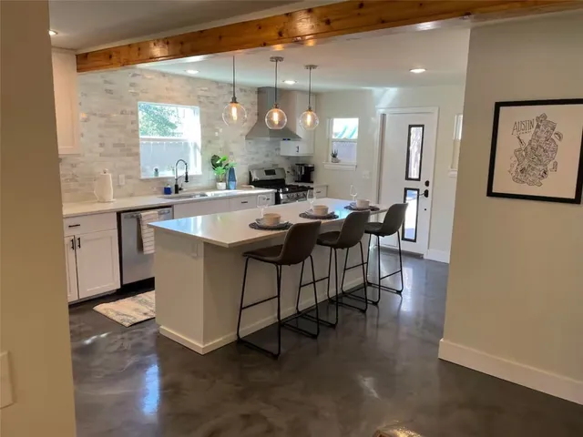 a dining hall with stainless steel appliances granite countertop a sink a stove and a refrigerator