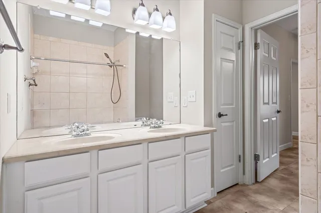 a bathroom with a sink vanity granite shower and a mirror