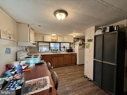 a kitchen view with stainless steel appliances granite countertop a refrigerator a stove and a sink