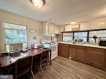 a kitchen with a dining table chairs cabinets and appliances