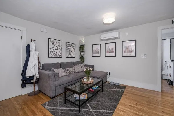 a living room with furniture a window and a wooden floor